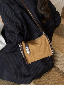 Brown quilted crossbody bag with suede finish and silver hardware on a model