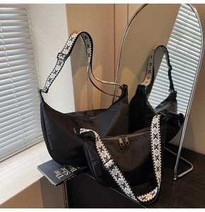 Detail view of black oxford crescent bags with adjustable geometric woven shoulder straps