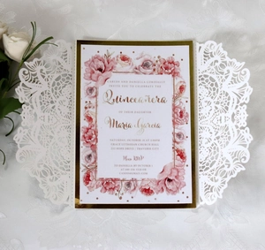 Detail of laser cut lace sleeve with floral watercolor invitation card and gold border