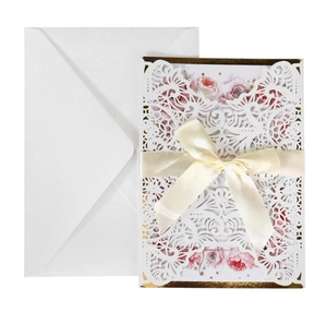 Laser cut deep purple wedding invitation set with floral card and satin bow on white background