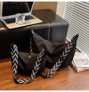 Detailed view of black nylon crescent bags in two sizes with woven herringbone straps