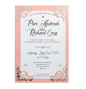 Détail macro de l'invitation de mariage découpée au laser avec motifs roses pailletés