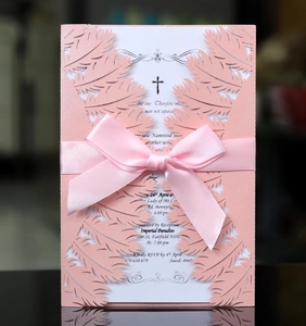 Pink laser-cut wedding invitation featuring a satin bow and delicate feather texture pattern