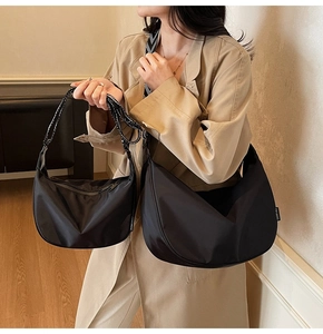 Detail of black crescent oxford bags in two sizes with trendy polka dot shoulder straps