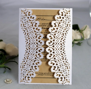 Détail du faire-part de mariage en dentelle blanche découpée au laser avec carte en kraft