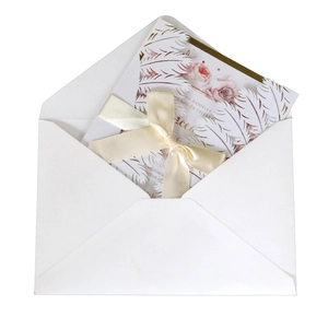 Elegant laser-cut white feather wedding invitation with floral insert and satin ribbon