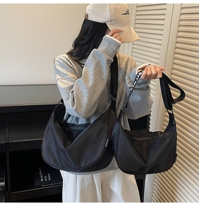 Comparison of small and large black nylon hobo bags with branded woven shoulder straps