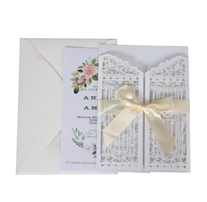 Laser-cut wedding invitation set featuring floral inner card, ribbon bow and envelope