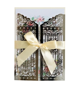 Detailed laser-cut silver gate invitation cover with champagne ribbon and floral card