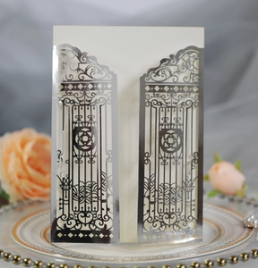Detail of silver laser-cut gatefold wedding invitation with intricate filigree patterns