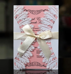 Macro detail of laser-cut feather lace pattern with pink card and silk ribbon bow