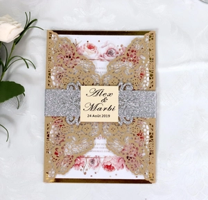 Détail d'une invitation de mariage dorée découpée au laser avec bandeau pailleté chic