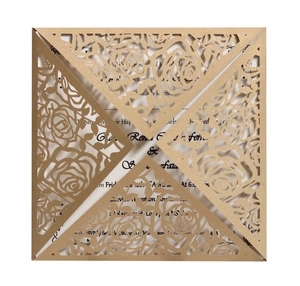 Detail of laser-cut gold rose pattern invitation with intricate floral lace texture