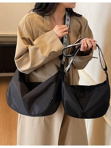 Black nylon dumpling bag in large and small sizes with geometric strap and crossbody style
