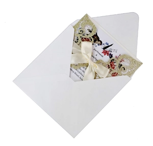 Elegant laser-cut glitter wedding invitation with ivory satin bow and floral inner card