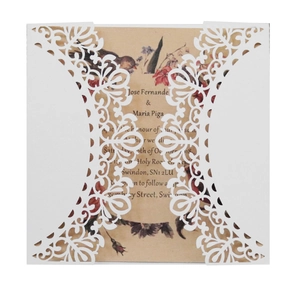 Detail of laser-cut wedding invitation with intricate floral patterns and vintage insert card