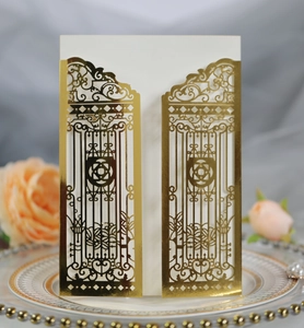 Close-up of laser-cut gold gate wedding invitation with elegant floral hollow patterns