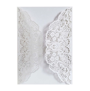 Detailed macro view of white laser-cut floral lace invitation card made from art paper