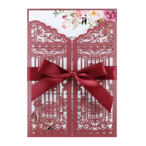Elegant burgundy laser-cut wedding invitation with a satin bow and floral inner card