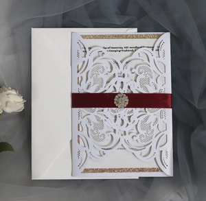 Faire-part de mariage découpé au laser avec ruban de satin rouge et boucle en strass