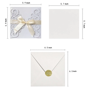 Laser-cut white wedding invitation set with ribbon, inner card, and invitation envelope