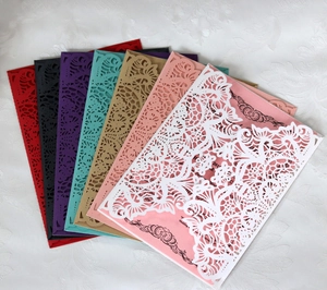 Close-up of laser-cut floral patterns on elegant multi-color wedding invitations
