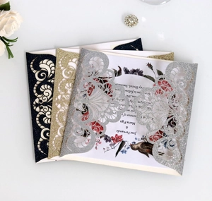 Detail of laser cut wedding invitation covers in navy blue, gold and silver glitter paper