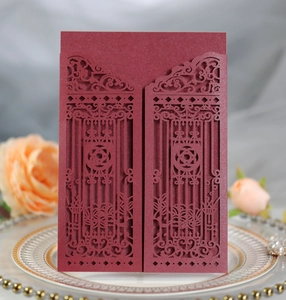 Macro detail of laser-cut burgundy wedding invitation with elegant gate flower pattern