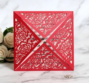 Close-up of laser-cut red rose floral wedding invitation with white insert card