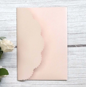 Elegant laser-cut pearlized light pink wedding invitation envelope with scalloped edges