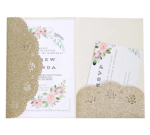 Macro view of laser cut rose pattern on golden glitter cardstock wedding invitation set