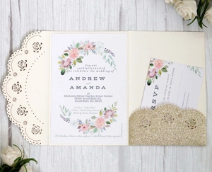 Detail of laser-cut ivory wedding invitation with rose patterns and gold glitter pocket