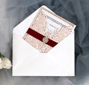 Detail of pink laser-cut 40th birthday invitation with burgundy velvet belt and rhinestone