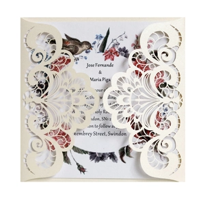 Laser cut ivory wedding invitation with elegant floral scrollwork and inner card
