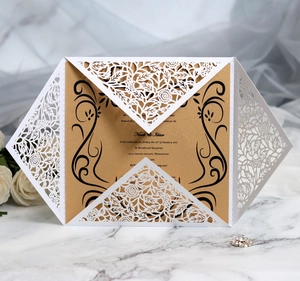 Macro detail of laser-cut floral invitation with elegant gold inner card on marble surface