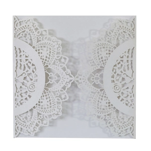 Macro shot of white laser-cut floral lace wedding invitation with pearlescent finish