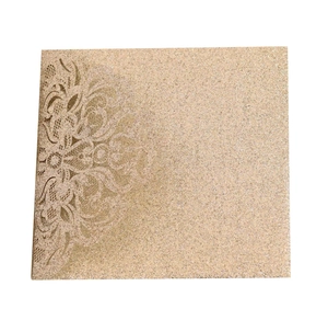 Detail of laser-cut floral patterns on champagne gold glitter wedding invitation card