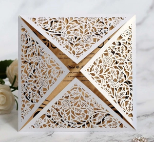 Detail of white laser-cut rose lace wedding invitation with gold insert card