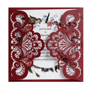 Detail of laser-cut burgundy wedding invitation featuring intricate floral lace patterns