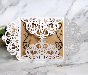 Macro detail of laser-cut lace wedding invitation with gold inner card and floral patterns