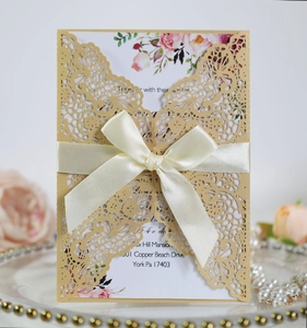 Detailed laser cut wedding invitation with elegant satin ribbon and floral insert card