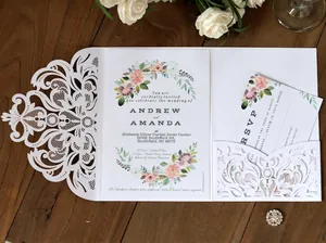 Elegant laser cut white floral wedding invitation set on wood with RSVP card