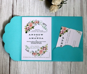 Detailed set of blue pocket wedding invitations with floral RSVP cards on grey wood