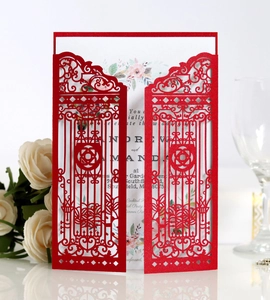 Detail of red laser-cut wedding invitation featuring intricate garden gate patterns