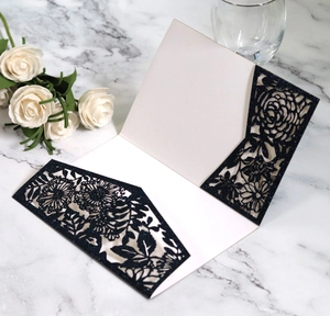 Navy blue hollow rose laser cut engagement invitation card with gold glitter on marble table