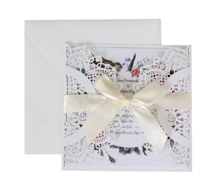 Laser cut wedding invitation set with intricate lace detail and cream silk ribbon bow