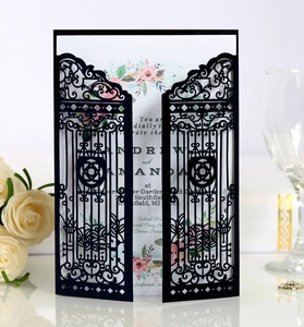 Detailed laser-cut gate design on black wedding invitation sleeve with floral inner card