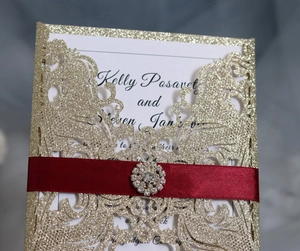Dettaglio dell'invito tagliato al laser con glitter, nastro rosso e fibbia di strass