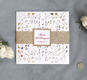 Detailed laser cut white floral wedding invitation with gold glitter band and custom names