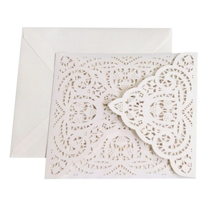 Detailed macro view of laser-cut pearl paper wedding invitation with white floral lace patterns